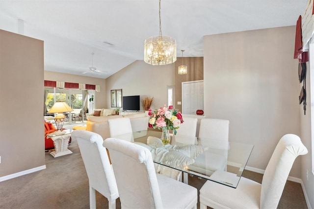 dining room featuring vaulted ceiling, ceiling fan with notable chandelier, carpet flooring, and baseboards