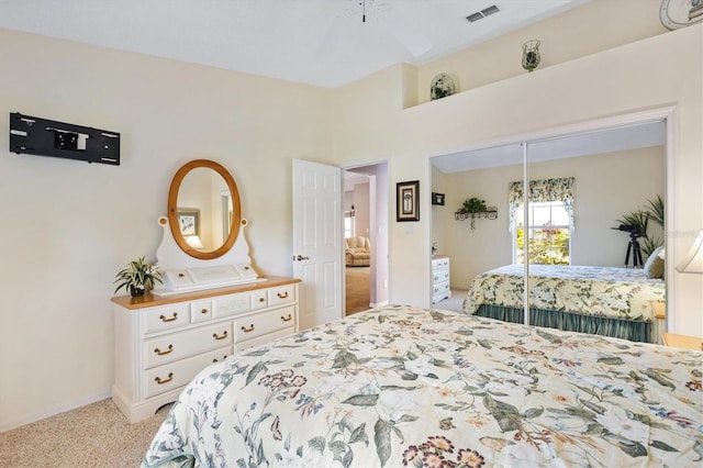 bedroom featuring baseboards, visible vents, a closet, and light colored carpet