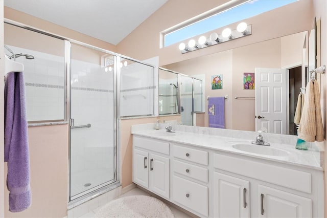 bathroom with double vanity, a stall shower, and a sink