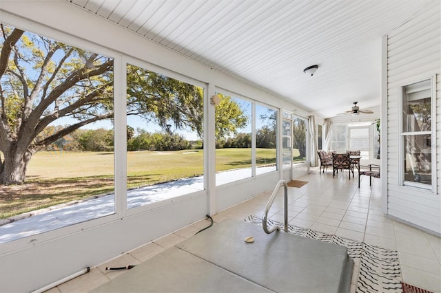 unfurnished sunroom featuring a ceiling fan