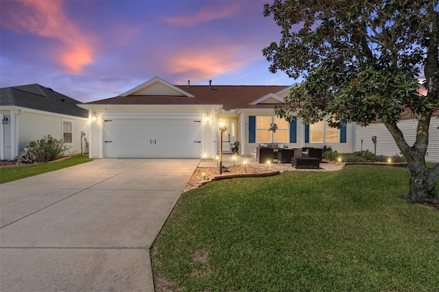 single story home featuring an attached garage, a lawn, and concrete driveway