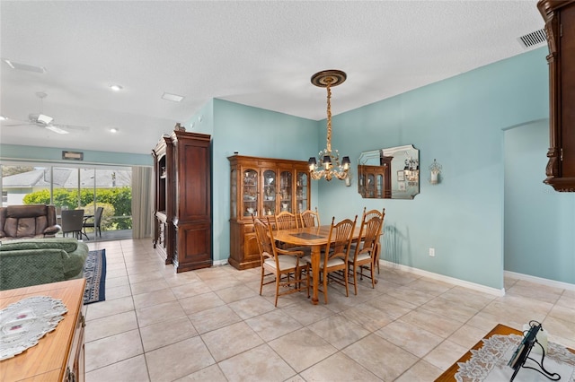 dining area with light tile patterned floors, a textured ceiling, ceiling fan with notable chandelier, visible vents, and baseboards