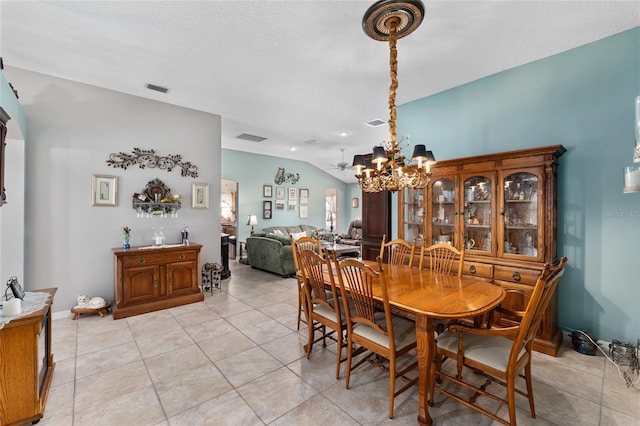 dining space with vaulted ceiling, light tile patterned floors, visible vents, and a notable chandelier