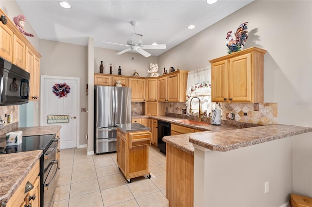 kitchen featuring light tile patterned flooring, a peninsula, a sink, backsplash, and black appliances