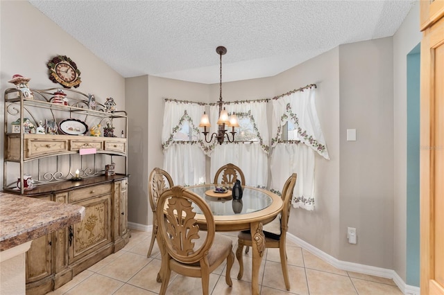 dining space featuring light tile patterned floors, a textured ceiling, baseboards, and an inviting chandelier