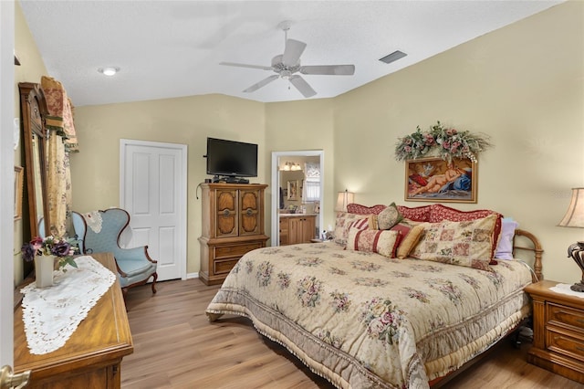 bedroom with light wood-style floors, ceiling fan, visible vents, and vaulted ceiling