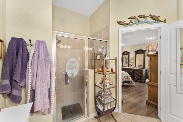 bathroom featuring a stall shower, connected bathroom, and tile patterned floors