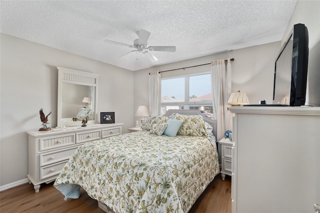 bedroom featuring a textured ceiling, baseboards, and dark wood-type flooring