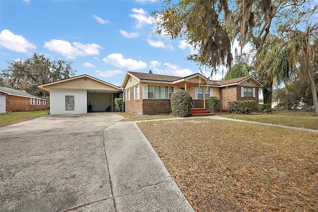 single story home featuring a front lawn, concrete driveway, and brick siding