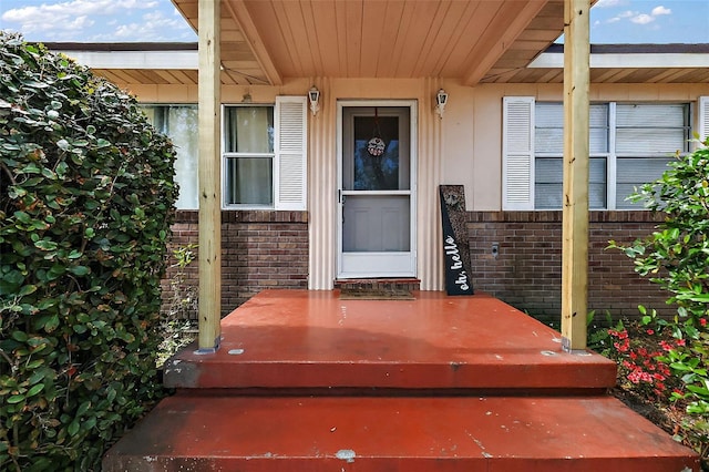 view of exterior entry with brick siding