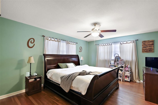 bedroom featuring dark wood-style floors, ceiling fan, and baseboards