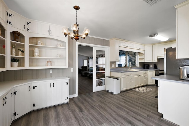 kitchen featuring dark wood-style floors, decorative light fixtures, a sink, and open shelves