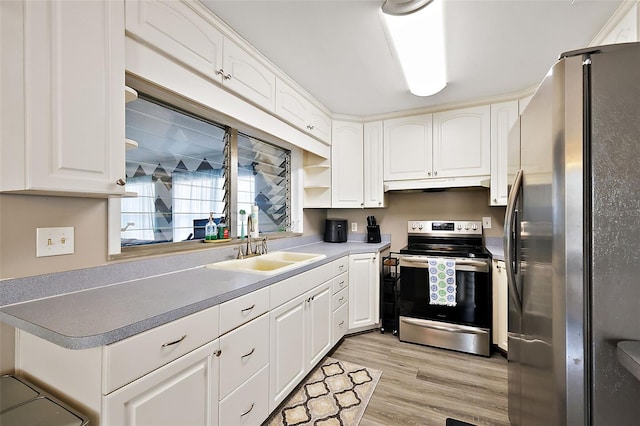 kitchen featuring under cabinet range hood, stainless steel appliances, a sink, white cabinetry, and light wood-style floors