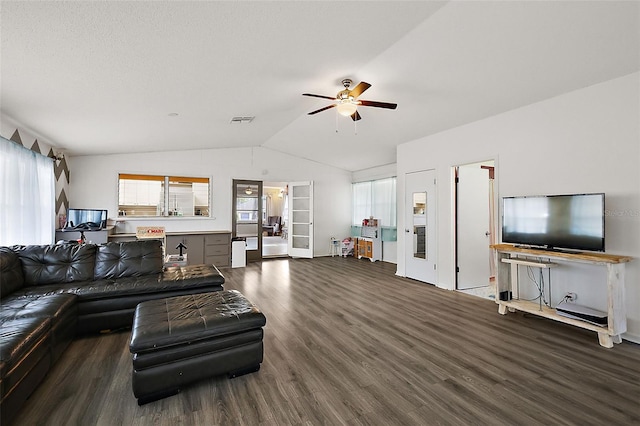 living area with a ceiling fan, visible vents, vaulted ceiling, and wood finished floors