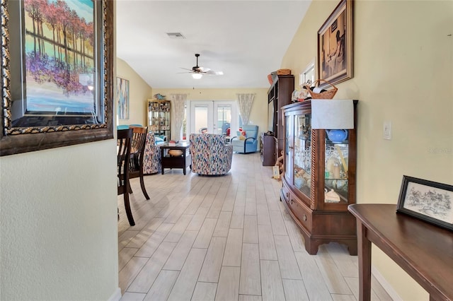 interior space with visible vents, wood finish floors, ceiling fan, vaulted ceiling, and french doors