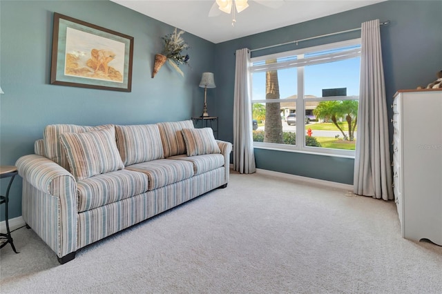 carpeted living area featuring a ceiling fan and baseboards