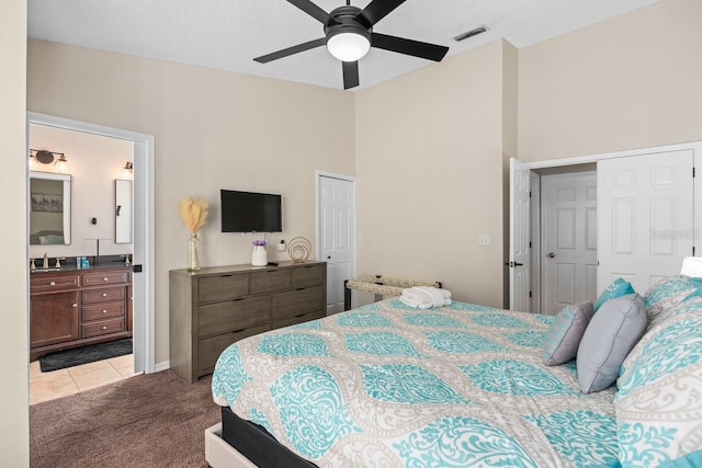 bedroom featuring ensuite bathroom, light colored carpet, a sink, a ceiling fan, and visible vents