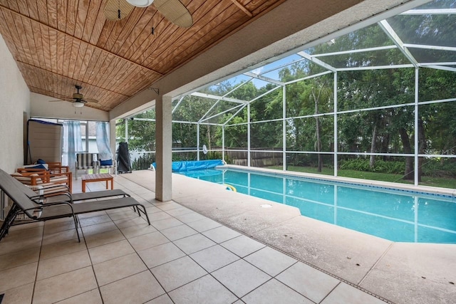 pool with a ceiling fan, glass enclosure, and a patio area