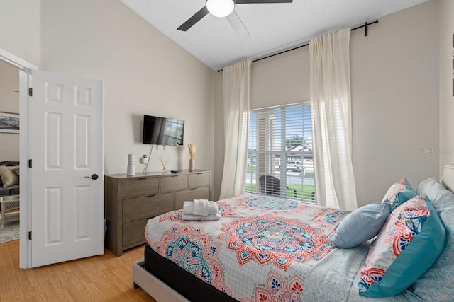 bedroom featuring lofted ceiling, light wood-style flooring, and ceiling fan