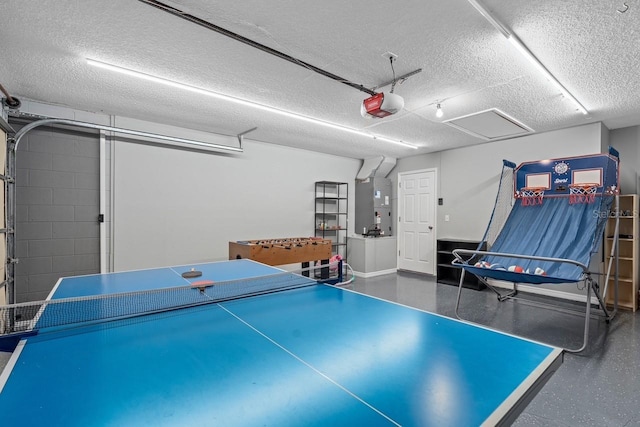 rec room with a garage, heating unit, a textured ceiling, and baseboards