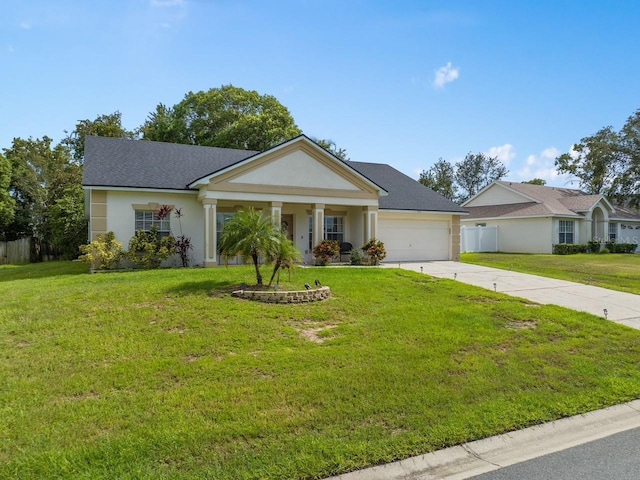 view of front facade featuring a garage, a front yard, driveway, and stucco siding