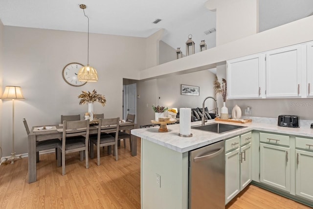 kitchen with a sink, high vaulted ceiling, light wood-type flooring, dishwasher, and a peninsula