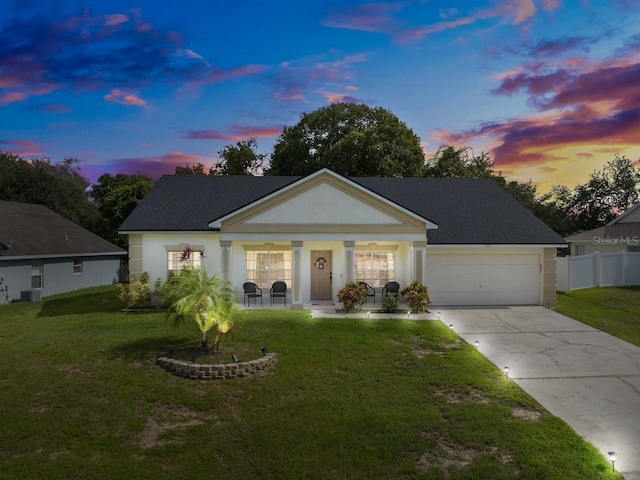 view of front facade with a front lawn, concrete driveway, and stucco siding