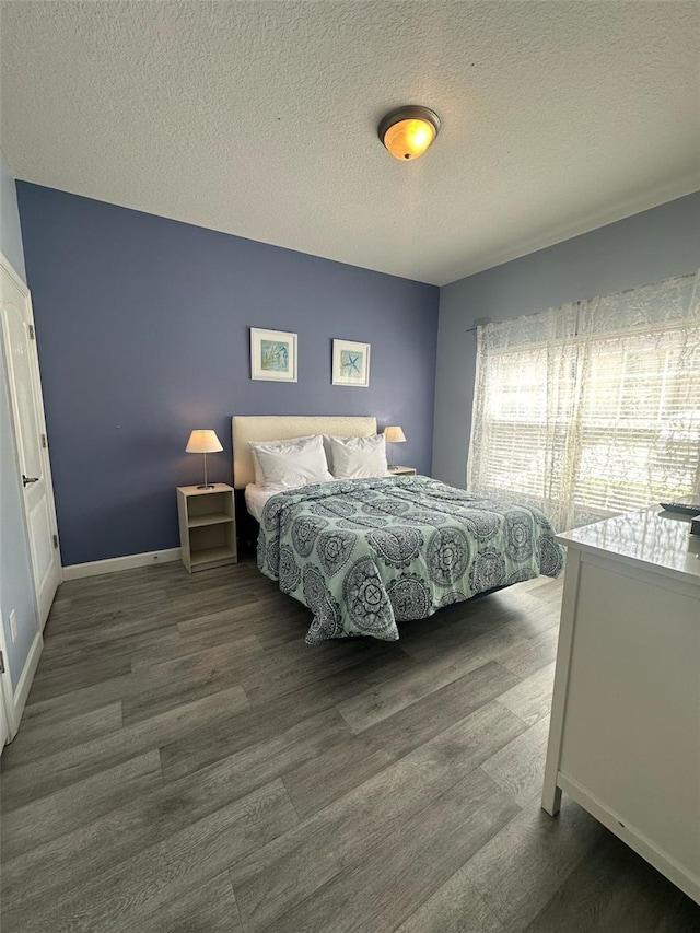 bedroom with a textured ceiling and wood finished floors