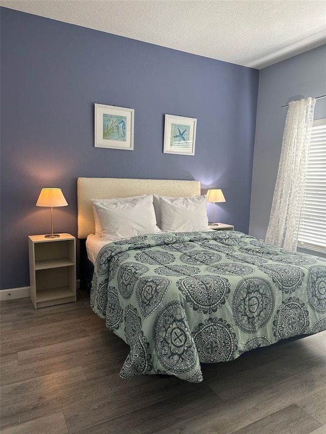 bedroom with a textured ceiling and wood finished floors