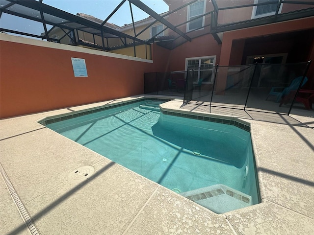 outdoor pool with a patio and glass enclosure