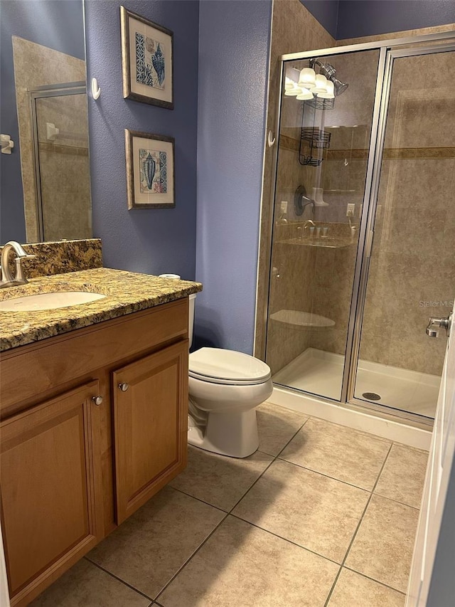 full bath with tile patterned floors, a shower stall, and vanity