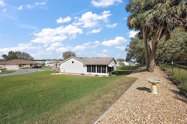 view of front of property featuring a sunroom, fence, and a front yard