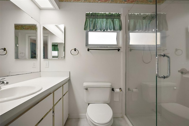 full bathroom featuring a stall shower, baseboards, vanity, and toilet