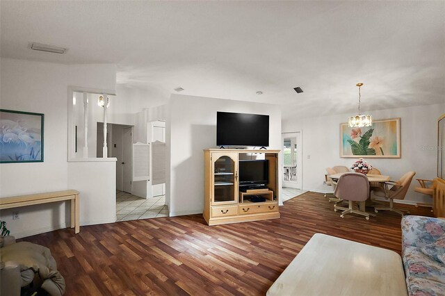 living room featuring wood finished floors, visible vents, and an inviting chandelier