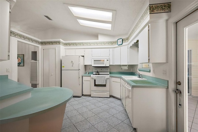 kitchen with lofted ceiling, white appliances, a sink, white cabinets, and light countertops