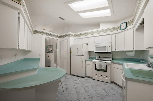 kitchen featuring lofted ceiling, visible vents, white cabinetry, a sink, and white appliances