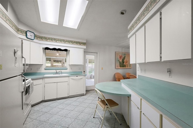 kitchen featuring light countertops, white appliances, and white cabinetry