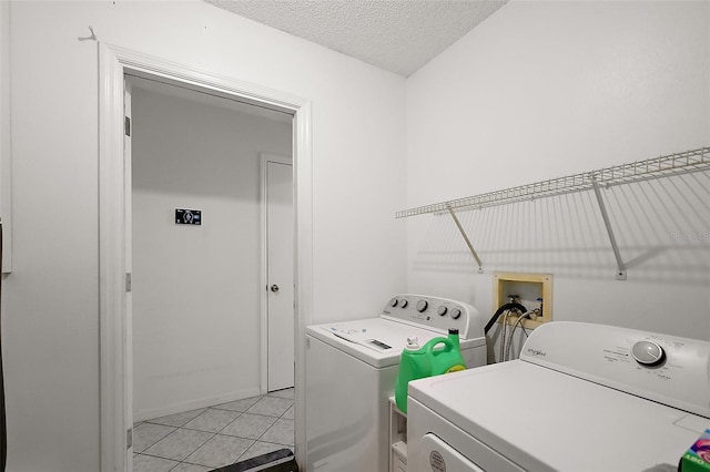 clothes washing area with washing machine and dryer, laundry area, and a textured ceiling