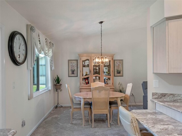 dining space with a chandelier, light carpet, and baseboards