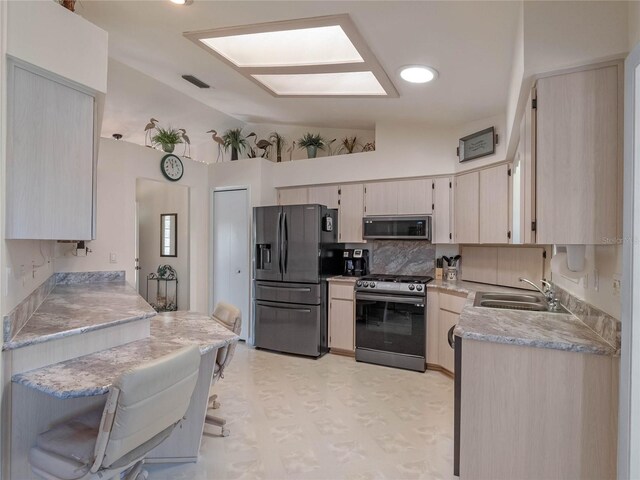 kitchen with visible vents, a sink, stainless steel appliances, light countertops, and lofted ceiling