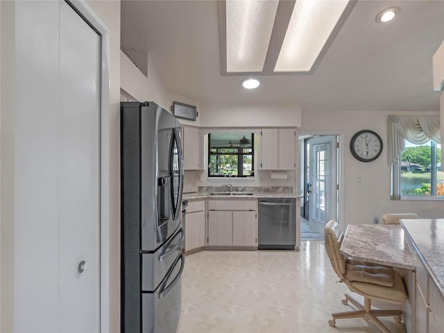 kitchen with a sink, light floors, appliances with stainless steel finishes, and recessed lighting