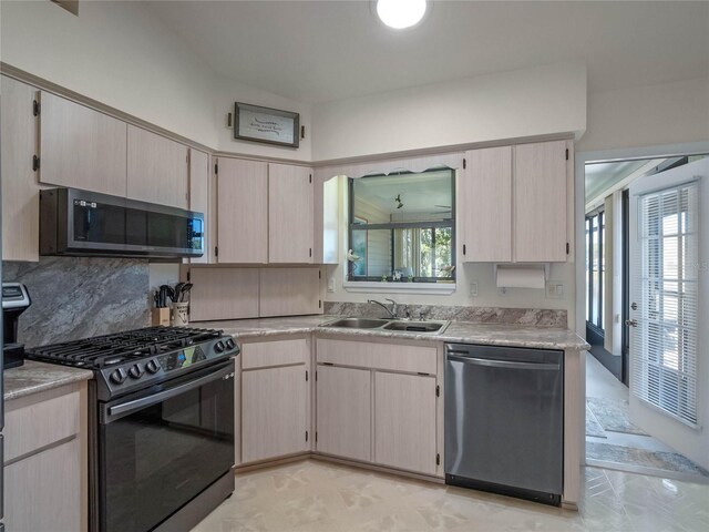 kitchen featuring a sink, stainless steel appliances, tasteful backsplash, and light countertops