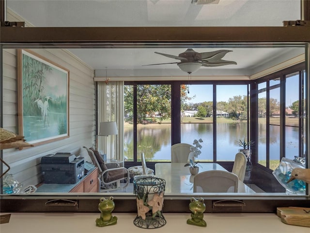 sunroom / solarium featuring a water view and ceiling fan