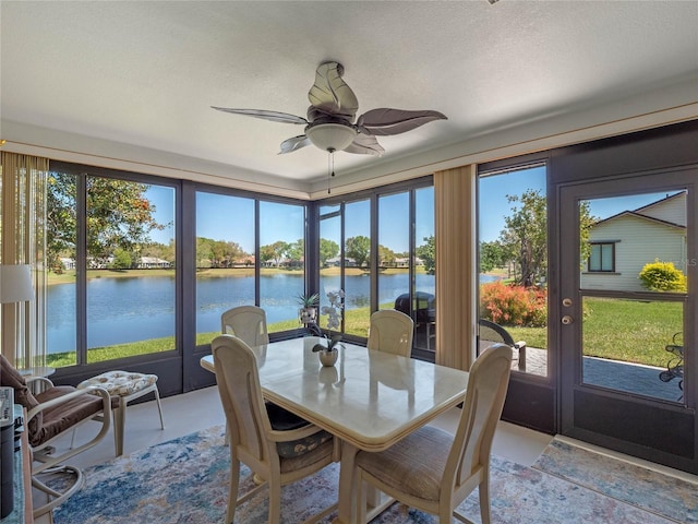 sunroom / solarium featuring a water view and a ceiling fan