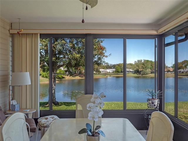 sunroom featuring a water view