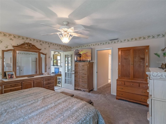 unfurnished bedroom with light colored carpet, a textured ceiling, and a ceiling fan