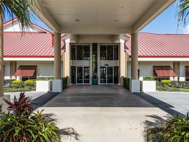 entrance to property featuring stucco siding, metal roof, and a standing seam roof