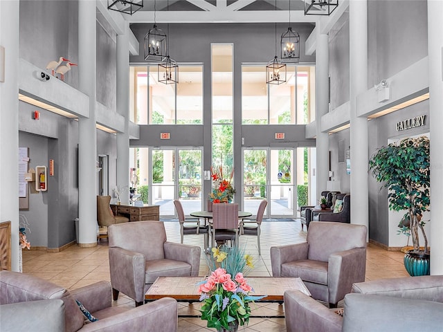 interior space with tile patterned floors, an inviting chandelier, and a towering ceiling