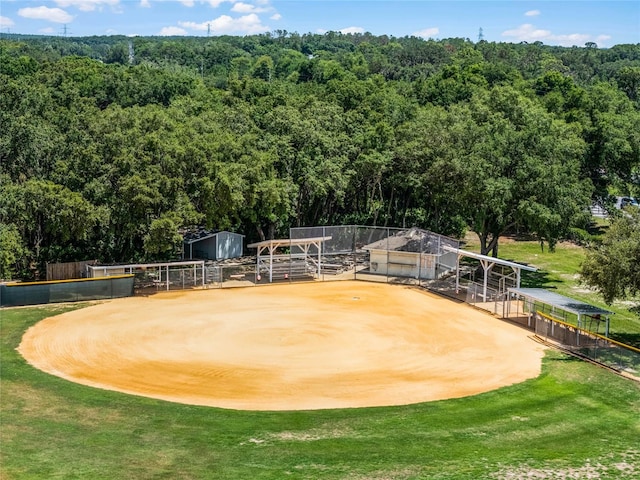 view of property's community featuring an outdoor structure, a view of trees, and an exterior structure