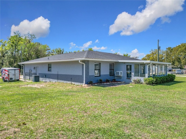 back of property with a lawn, cooling unit, a sunroom, and stucco siding